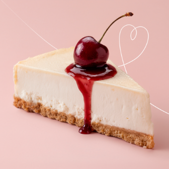 Slice of cheesecake topped with cherry and red sauce on a pastel background