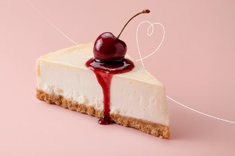 Slice of cheesecake topped with cherry and red sauce on a pastel background.